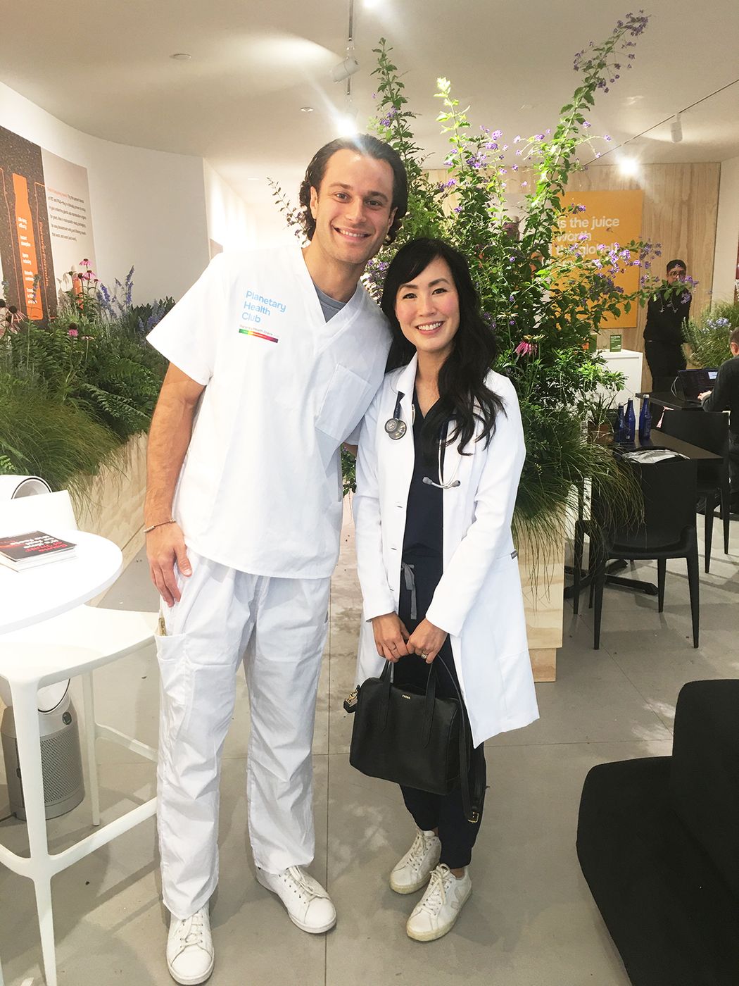 Dr. Melissa Lem with a Planetary Health Club host, both in white coats